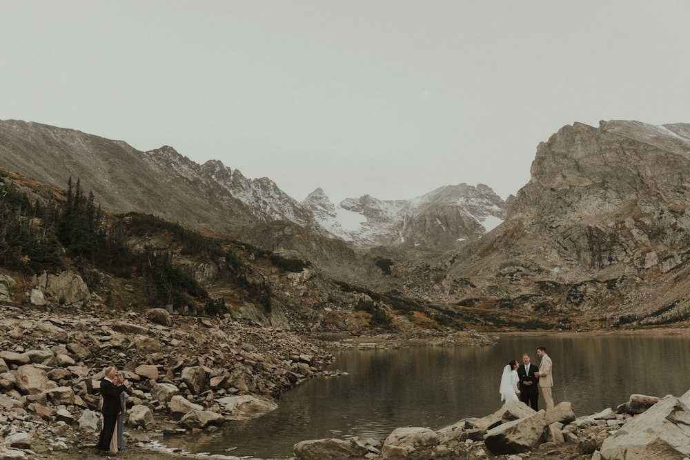 Two people standing together on top of a mountain