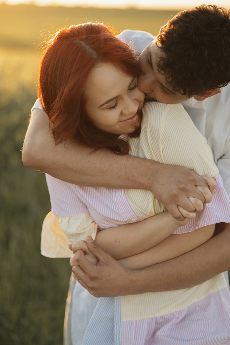 A couple embracing in an open field in warm evening light
