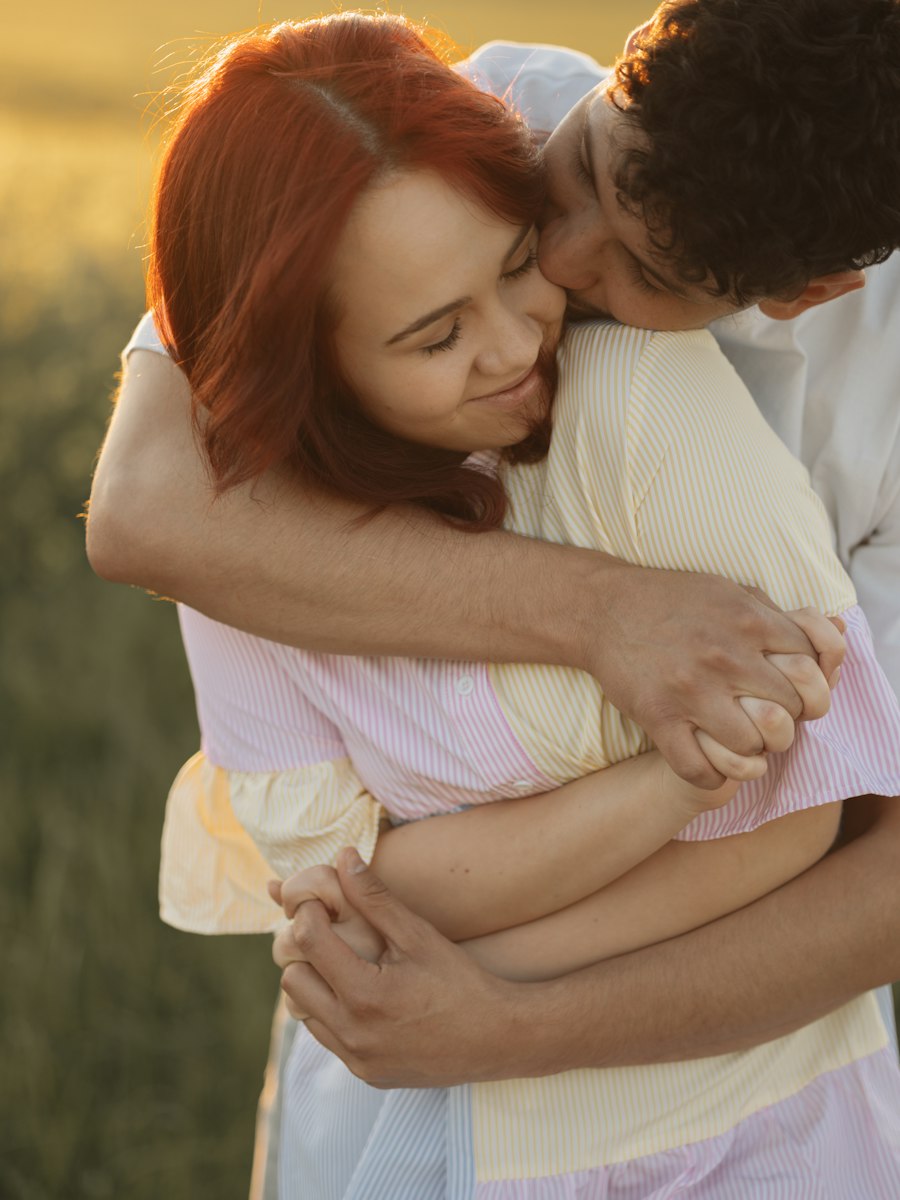 A couple embracing in an open field in warm evening light