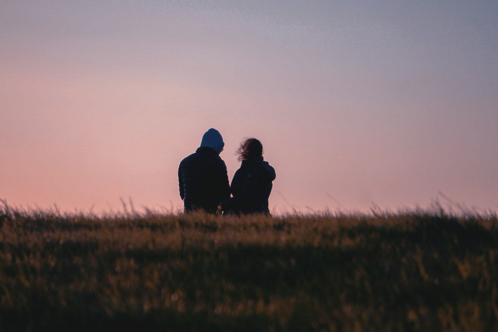 A couple sitting together on a grassy field